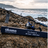 Okuma Fin Chaser rod and reel combo set up on a shoreline